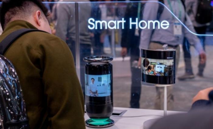 Man standing at a tech exhibit examining a new Smart Home camera product