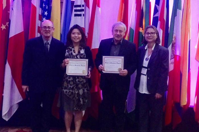 Lynsie Chew (middle left) and Alan Parkinson (middle right) collect their award at the Global Conference on Business and Finance