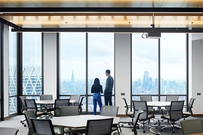 A photo of two people overlooking the City of London from Level 50, One Canada Square