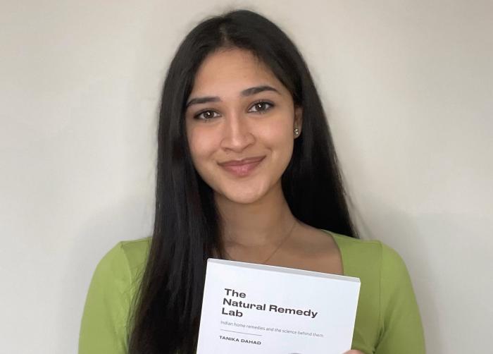 Photo of Tanika holding her book titled: "The Natural Remedy Lab"