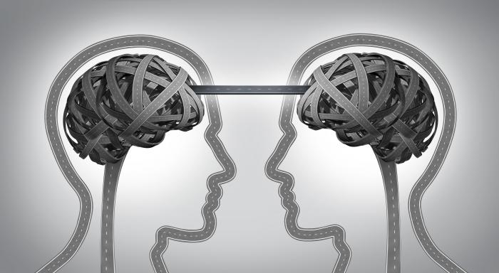 Black and white of two heads silhouettes facing each other with the brains linked to represent psychological contract